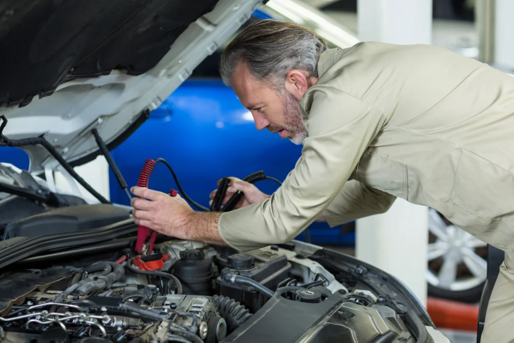 mechanic-attaching-jumper-cables-car-battery-scaled